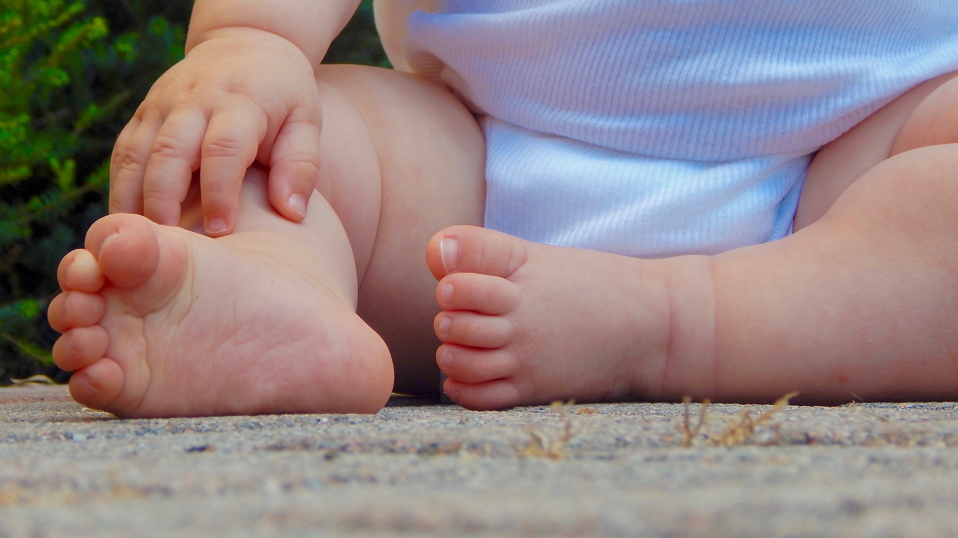 Malattia genetica rara, inquadratura dei piedini di un bimbo seduto
