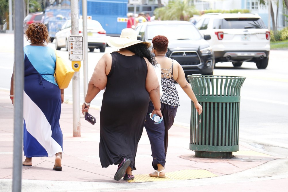 obesità, una donna obesa passeggia in strada