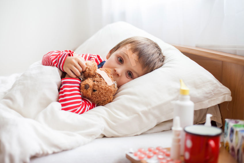 Cancro pediatrico, un bambino a letto con un pupazzo di peluche tra le braccia