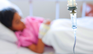 Una bambina malata di tumore in un letto di ospedale