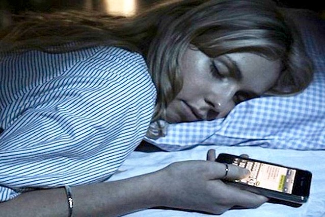10 consigli efficaci per dormire bene. Nella foto una donna dorme con il cellulare in mano