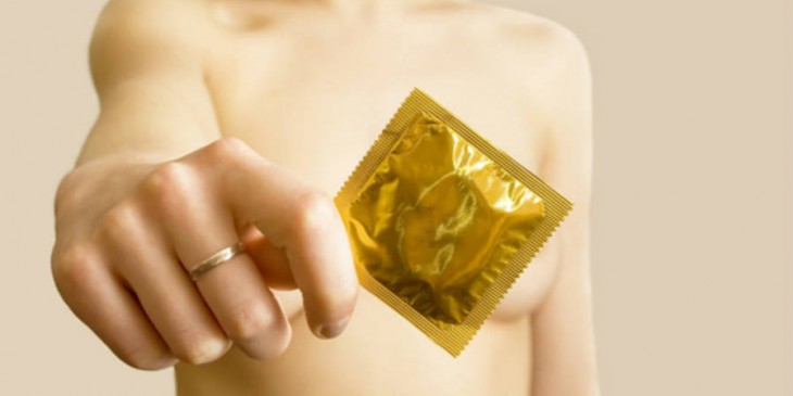una donna mostra in primo piano un preservativo per prevenire le Infezioni sessualmente trasmesse
