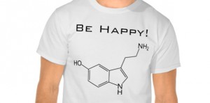 Un uomo indossa una maglietta con la scritta sii felice e il disegno della molecola della serotonina