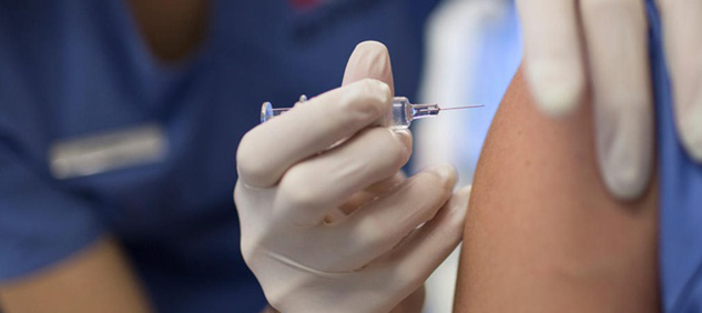 Vaccini influenza, medico inserisce ago in un braccio
