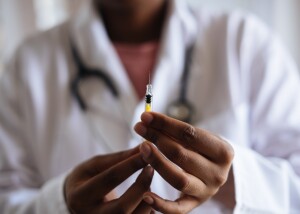 covid e vaccini mRna: un medico prepara siringa per vaccino