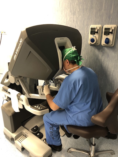 Tumore del pancreas: un chirurgo seduto alla consolle del robot operatorio Da Vinci
