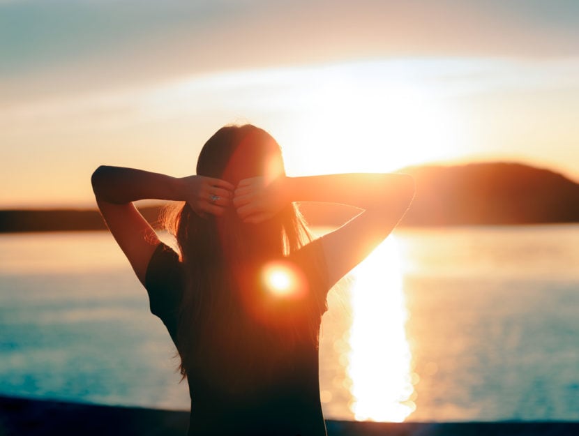 Una donna prende il sole al tramonto