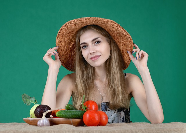 Pomodoro, una donna con un cappello di paglia e della verdura e ortaggi sul tavolo davanti a lei