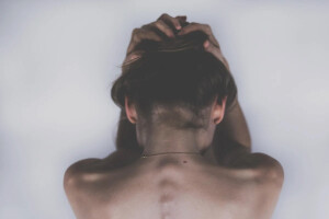 salute mentale: una donna di spalle si stringe la testa
