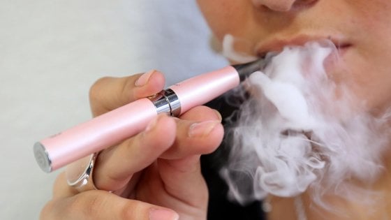 sigarette elettroniche: in primo piano una e-cig e una nuvola di fumo svapato dalla bocca di una persona