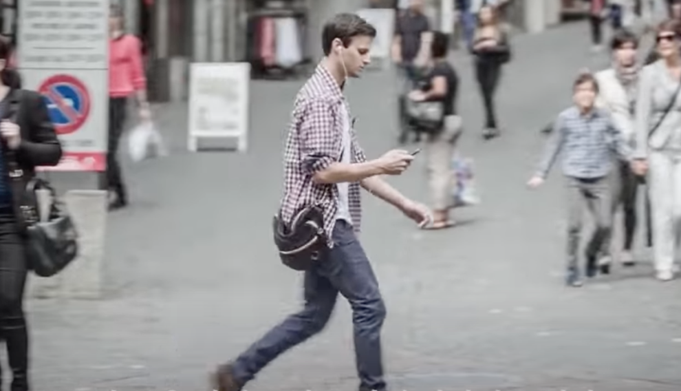 Un ragazzo usa il cellulare mentre passeggia