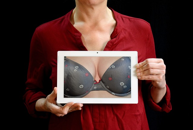 Carcinoma mammario, una donna tiene in mano una foto nella quale si vede un seno fasciato nel reggiseno. Il senso della foto è di parlare di prevenzione del tumore alla mammella