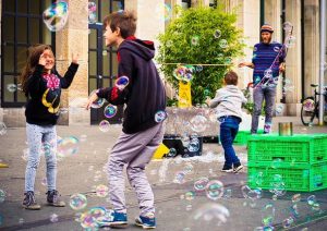 bambini giocano con bolle in città