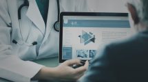 Digital health, un medico mostra schermo al paziente anziano
