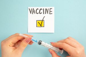 Fragilità severa e covid: vista-dall-alto-vaccino-nota-scritta-da-donna-su-sfondo-blu-vaccino-colore-