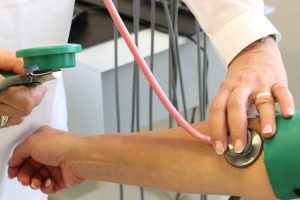 Visite gratuite, una dottoressa misura la pressione ad una paziente