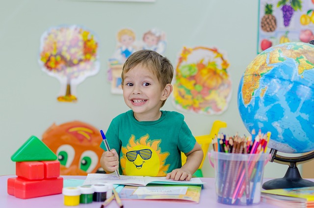 Rientro a scuola un bimbo sorride mentre colora un disegno