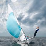 Sport per tutti: una vela naviga in mare piegata con due velisti a bordo