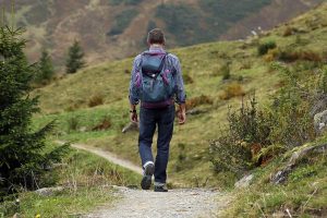 Trekking, un uomo passeggia lungo un sentiero di montagna