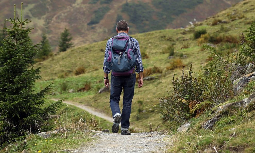 Trekking, un uomo passeggia lungo un sentiero di montagna